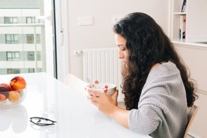 A woman eats breakfast as part of her residential eating disorder treatment programs